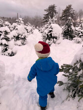 Load image into Gallery viewer, Toddler walking outside in the snow, amond the fir trees wearing a snowsuit and his Santa hat
