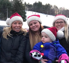 Load image into Gallery viewer, Family posing outside in the snow in their Santa hats
